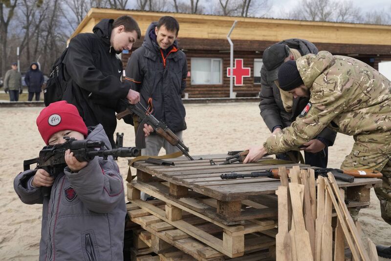 A boy plays with a weapon while an instructor shows a Kalashnikov assault rifle during training in Ukraine. Photo: AP/Efrem Lukatsky A boy plays with a weapon while an instructor shows a Kalashnikov assault rifle during training in Ukraine. Photo: AP/Efrem Lukatsky