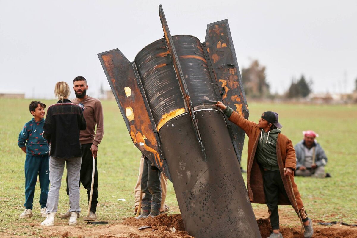 A boy touches an unexploded Iranian projectile that landed in an open field in the outskirts of Qamishli, eastern Syria, last month. Photo: AP/Baderkhan Ahmad
