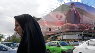 A pedestrian walks as vehicles drive past a billboard depicting Iran’s Supreme Leader Ayatollah Mojtaba Khamenei in central Tehran, Iran (Vahid Salemi/AP)