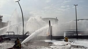 Firefighters extinguishing flames after an Iranian projectile struck an industrial area in Ma’ameer, Bahrain, last month (Bahrain Interior Ministry via AP, File)