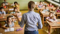 iStock-984739028.jpg Rear view of a female elementary teacher giving a lesson in the classroom.