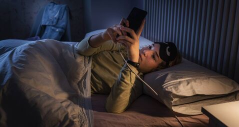 Teenage girl suffering sleeping disorders using smartphone at night