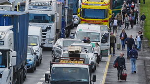 <p>People with their luggage walk past the heavy traffic on Dublin's M50 Northbound, due to vehicles taking part on the third day of a national fuel protest against rising fuel prices. Picture: Philip Toscano/PA</p>