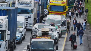 <p>People with their luggage walk past the heavy traffic on Dublin's M50 Northbound, due to vehicles taking part on the third day of a national fuel protest against rising fuel prices. Picture: Philip Toscano/PA</p>