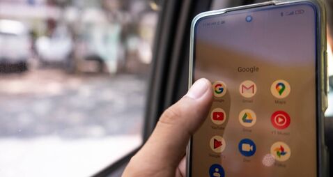 Closeup of a hand checking his Google apps, Gmail, Google Maps, Youtube