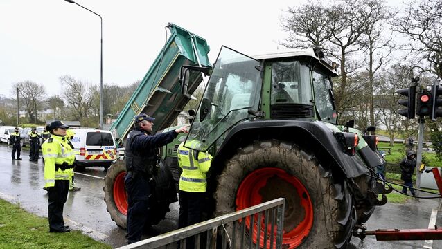 <p> Gardai speak with a tractor driver at the blockade on Friday at Whitegate, Cork. Picture: Larry Cummins</p>