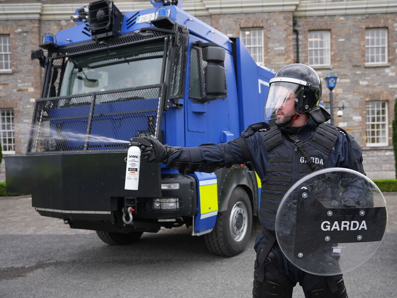 A member of the public order unit demonstrating the use of pepper spray next to a water cannon at Garda headquarters in Phoenix Park, Dublin last year. File picture: Niall Carson/PA 