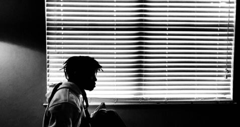 Side View Of Silhouette Man Sitting By Window