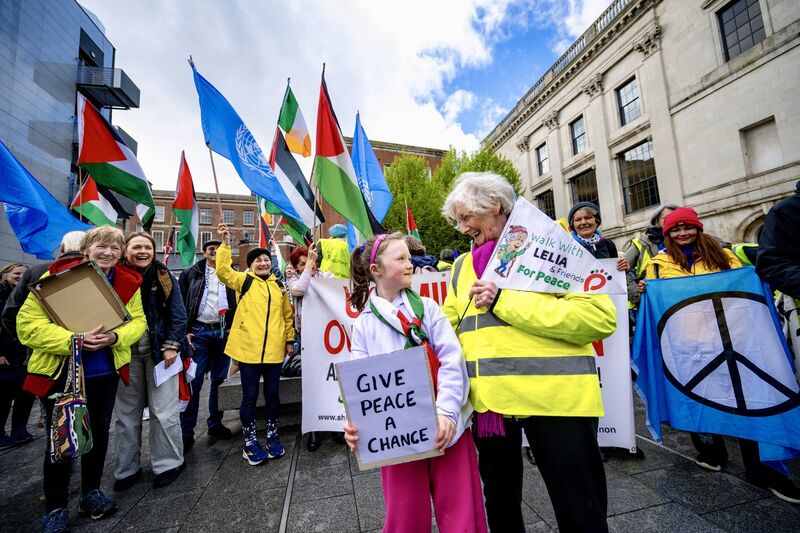 Florence Lohan, the youngest of the hundreds of peace campaigners — enjoying a day off school for the occasion — is greeted by 91-year-old activist Lelia Doolan outside Dublin Castle ahead of the final leg of her walk from Shannon to Dublin. Picture: Chani Anderson