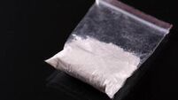 Cocaine in plastic packet on black background
