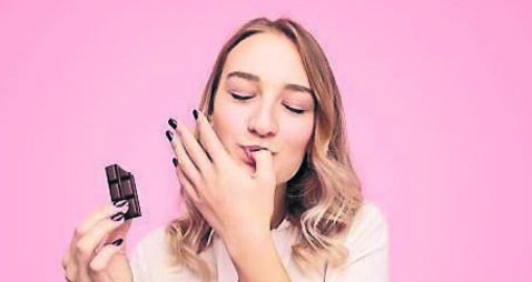 Young woman with chocolate licking finger