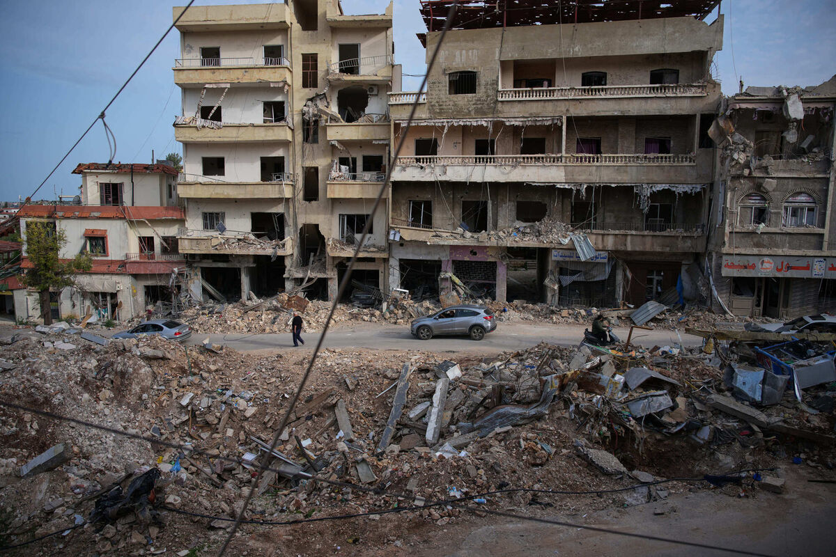 Locals drive past the site of buildings destroyed in an Israeli airstrike, in Jibchit, southern Lebanon, Friday, April 17, 2026, following a ceasefire between Israel and Hezbollah. (AP Photo/Hassan Ammar)