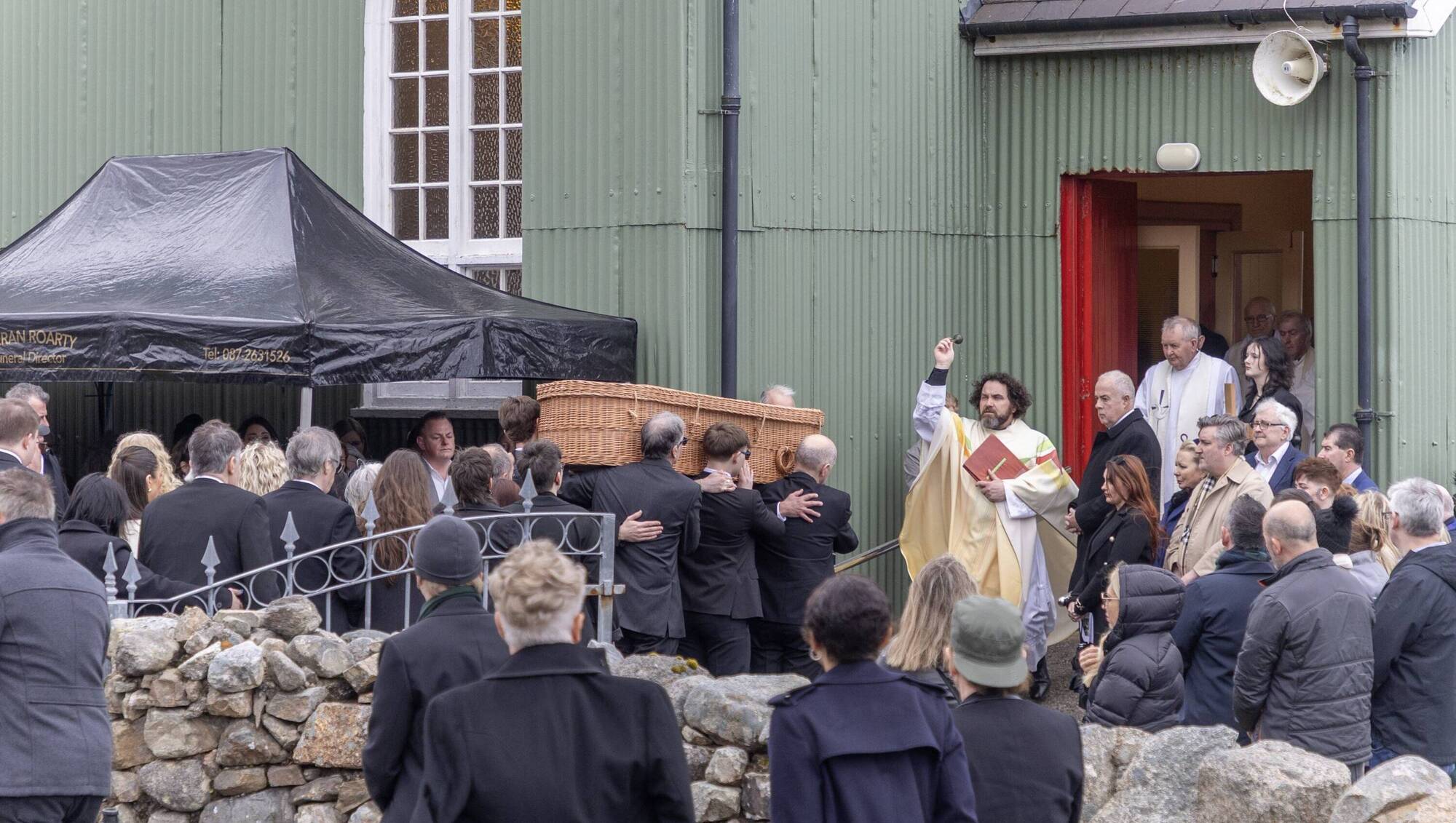 The remains of Moya Brennan arrives at Teach Pobail Phadraig Naofa is received with a blessing from Fr O'Fearraigh Picture: North West Newspix