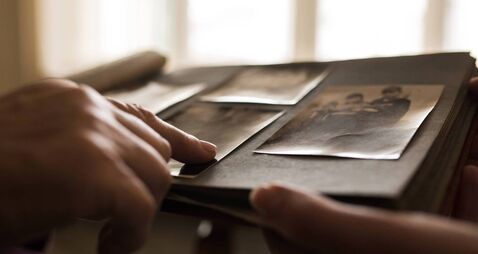 Close up human hand pointing to photo in photo album