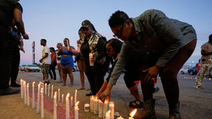 People light candles during a prayer vigil for the victims of a mass shooting earlier in the day, Sunday, April 19, 2026, in Shreveport, La. (AP Photo/Gerald Herbert)