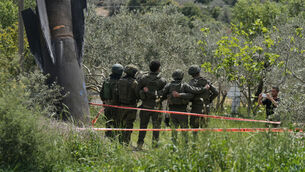 <p>Israeli soldiers take their photo beside the wreckage of an Iranian missile that landed in the West Bank village of Kifl Haris last month. Picture: Majdi Mohammed/AP</p>