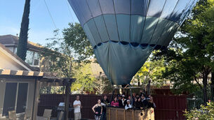 People in a hot air balloon pose for a photo after making an emergency landing in a back garden in Temecula, California (Hunter Perrin via AP)