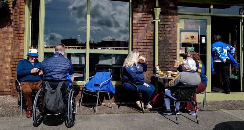 Supporters of Waterford, left, and Clare, relax, outside The Food Emporium, Francis Street, in Ennis before the Muntser SHC as Cusack Park. Pic: Ray McManus/Sportsfile