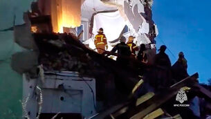 Russian Emergency Ministry employees work at the side of the damaged multi-storey apartment building hit by a Ukrainian drone in Syzran in Russia’s Samara region (Russian Emergency Ministry Press Service via AP)