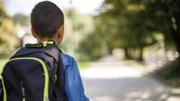 Teenage boy with school bag going home from school