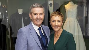 <p>Daniel O'Donnell and his wife, Majella, standing in front of their wedding outfits, which are now on display at Newbridge Silverware in Co. Kildare. Picture: Conor Healy / Picture It Photography</p>