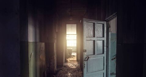 Dirty empty dark corridor in abandoned building, doors, light in the end, perspective, way to freedom