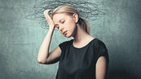 Woman with headache on grey background