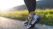 Low Section Of Woman Walking On Road In Mountains