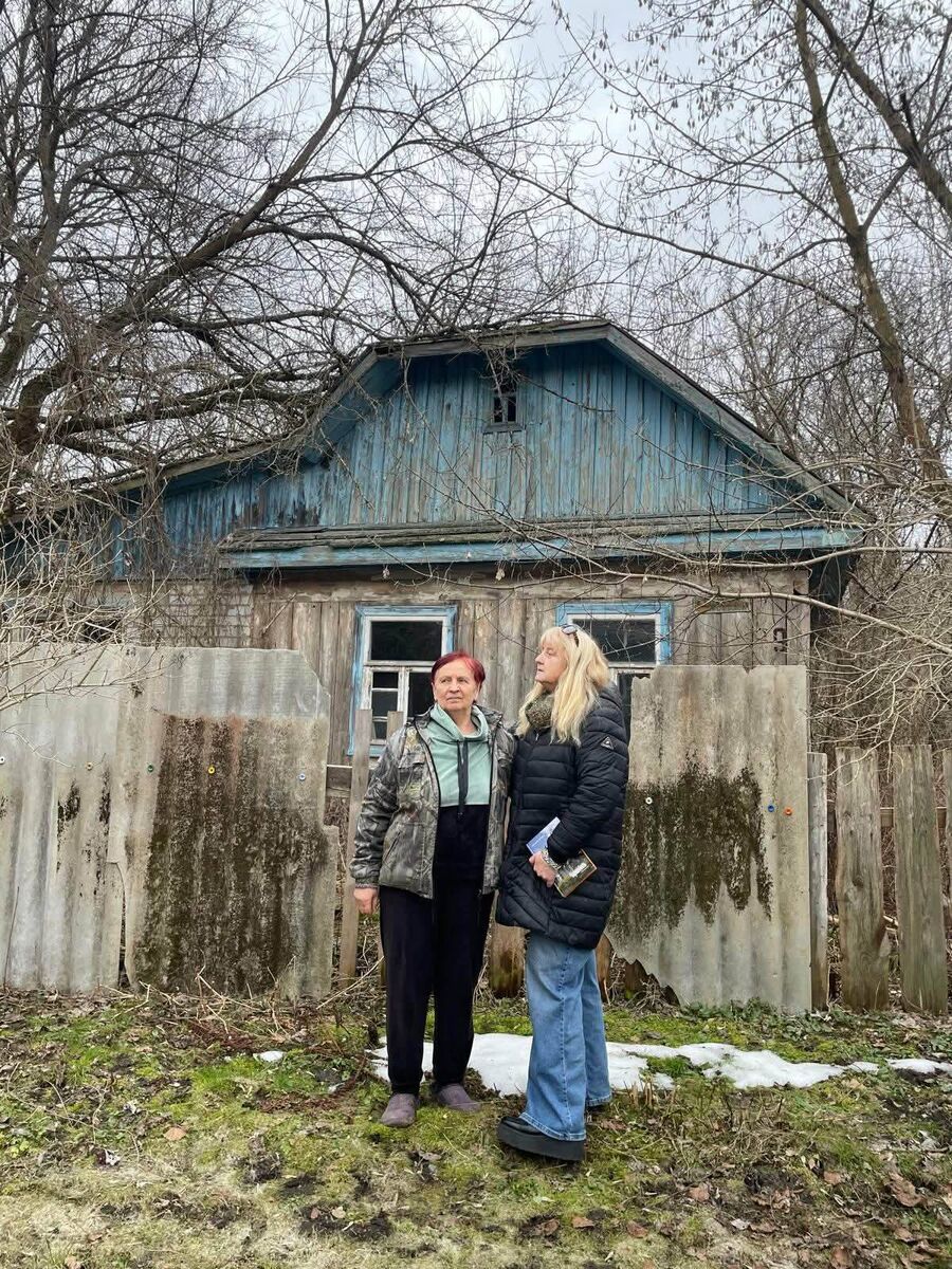 Maria Verbych (left) with Fiona Corcoran (right), outside her family home in Chornobyl. Maria describes the memory of the nuclear disaster as 'like a horror film' in which a once vibrant town became deserted overnight. 