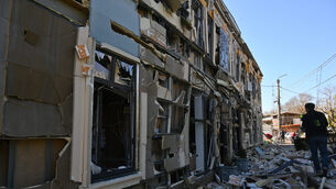 A person walks near residential houses damaged by a Russian strike in Odesa (Michael Shtekel/AP)