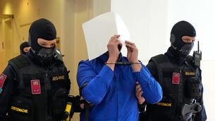 Defendant Beran A. hides his face on the way to court (Matthias Schrader/AP)