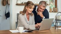A senior couple planning their finance and paying bills while using a laptop at home. A mature man and woman going through paper