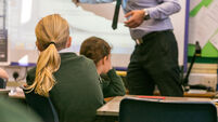 Primary school girls are taught during a lesson by a male teacher
