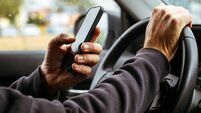 Male driver is driving car and texting on mobile phone