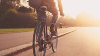 Young woman cycling in the park at sunset