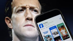 <p>Meta chief executive Mark Zuckerberg with a smartphone displaying the download page for the Facebook app. File picture: Drew Angerer/AFP/Getty Images</p>
