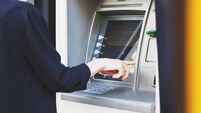 Business woman withdrawing money from ATM