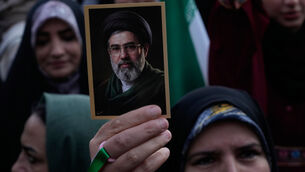 <p>A woman holds up a picture Ayatollah Mojtaba Khamenei during a state-organised rally in Tehran (Vahid Salemi/AP)</p>