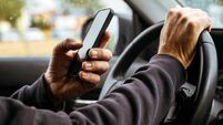 Male driver is driving car and texting on mobile phone