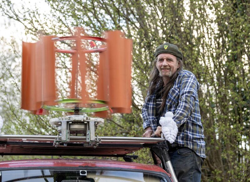 Barra with his wind turbine made from a sewer pipe, a bicycle wheel, and a washing machine motor. Barra with his wind turbine made from a sewer pipe, a bicycle wheel, and a washing machine motor.