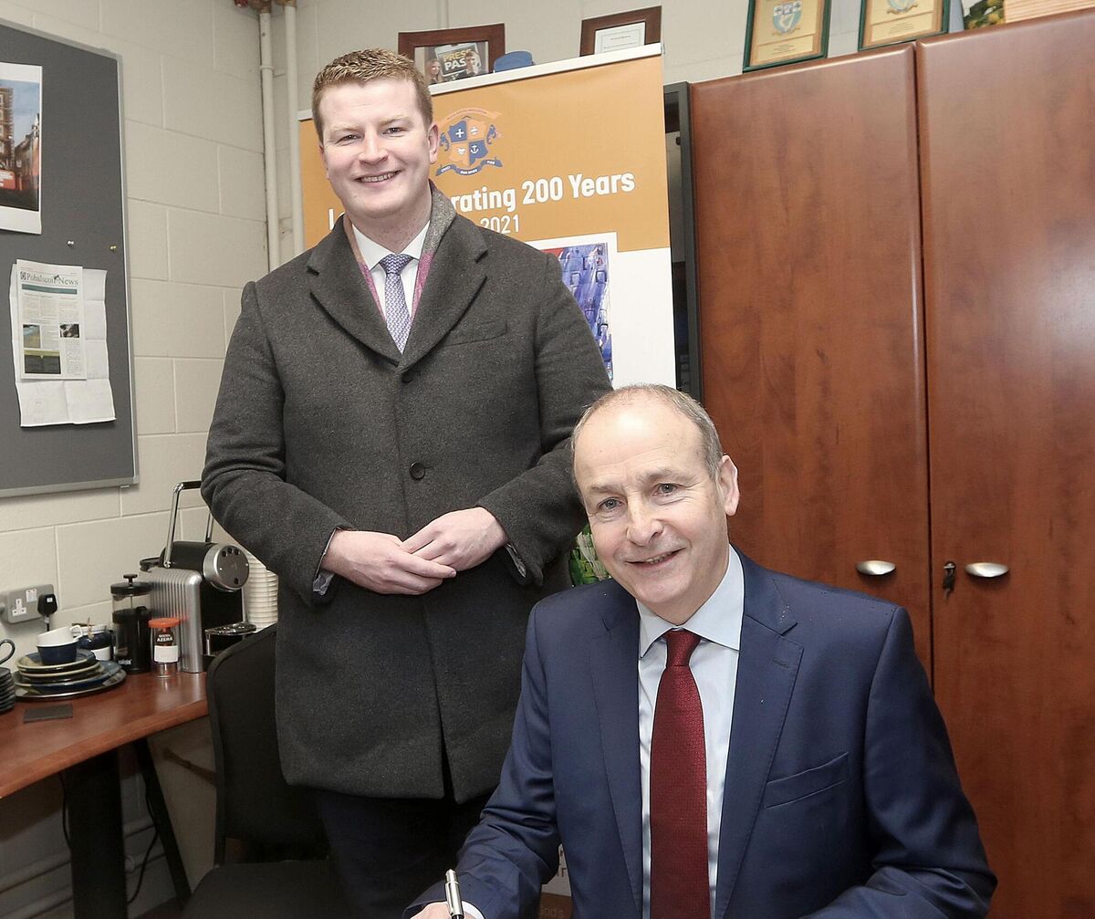Micheál Martin TD, signs Youghal Pobalscoil na Tríonóide’s visitor’s book with James O'Connor, Fianna Fail TD for Cork East, during Mr Martin’s visit to various schools in 2023. File picture: John Hennessy