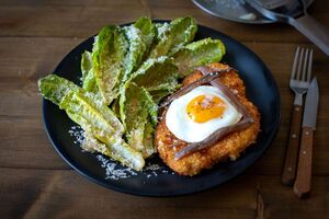 Chicken Schnitzel with fried egg and Caesar salad