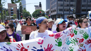 Demonstrators march during a May Day rally in Los Angeles (Jae C Hong/AP)