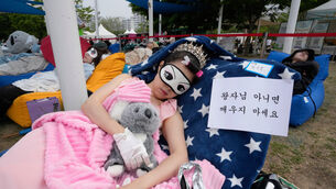 A participant takes a nap during the 2026 Hangang Nap Competition (Ahn Young-joon/AP)