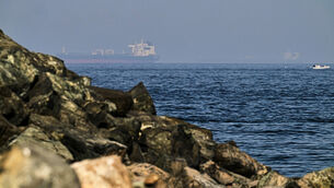 <p>Cargo ships are seen at sea in the Gulf of Oman near the Strait of Hormuz (Fatima Shbair/AP)</p>