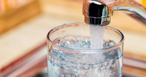 Filling up a glass with drinking water from kitchen tap