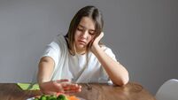 No vegan diet concept. Teen girl pushing away plate with broccoli and other vegetables refusing to eat. Food waste. Selective fo