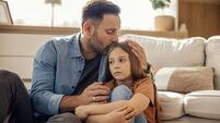 Father comforting sad daughter at home