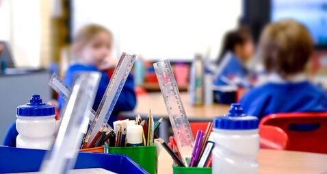 School classroom scene with kids learning in background