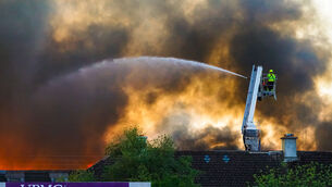 <p>Firefighters at the scene of a serious fire at the old Jute factory which made packaging in the Tycor Business Park. The fire was visible during the Cork vs Waterford Munster Senior Championship game at Walsh Park. Picture:  Noel Sweeney</p>